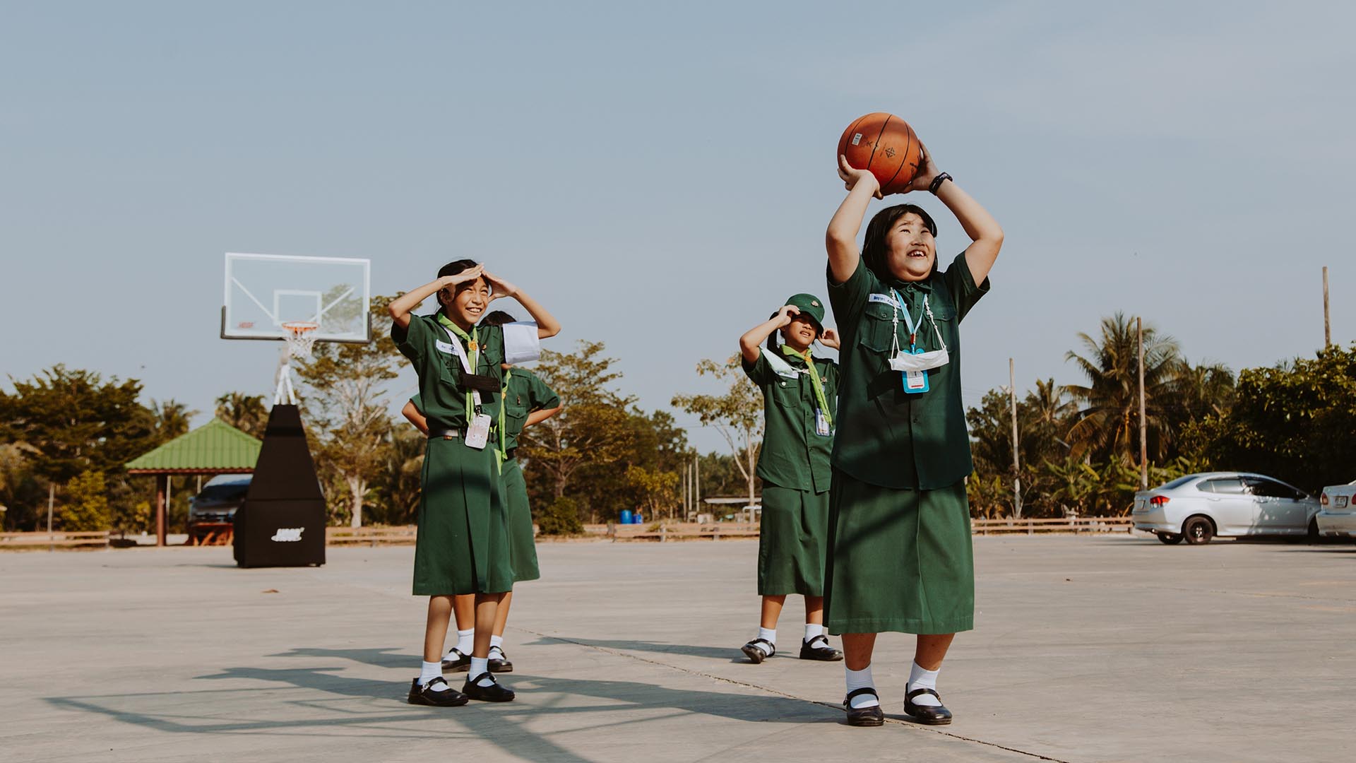 Photo of three school girls playing basketball