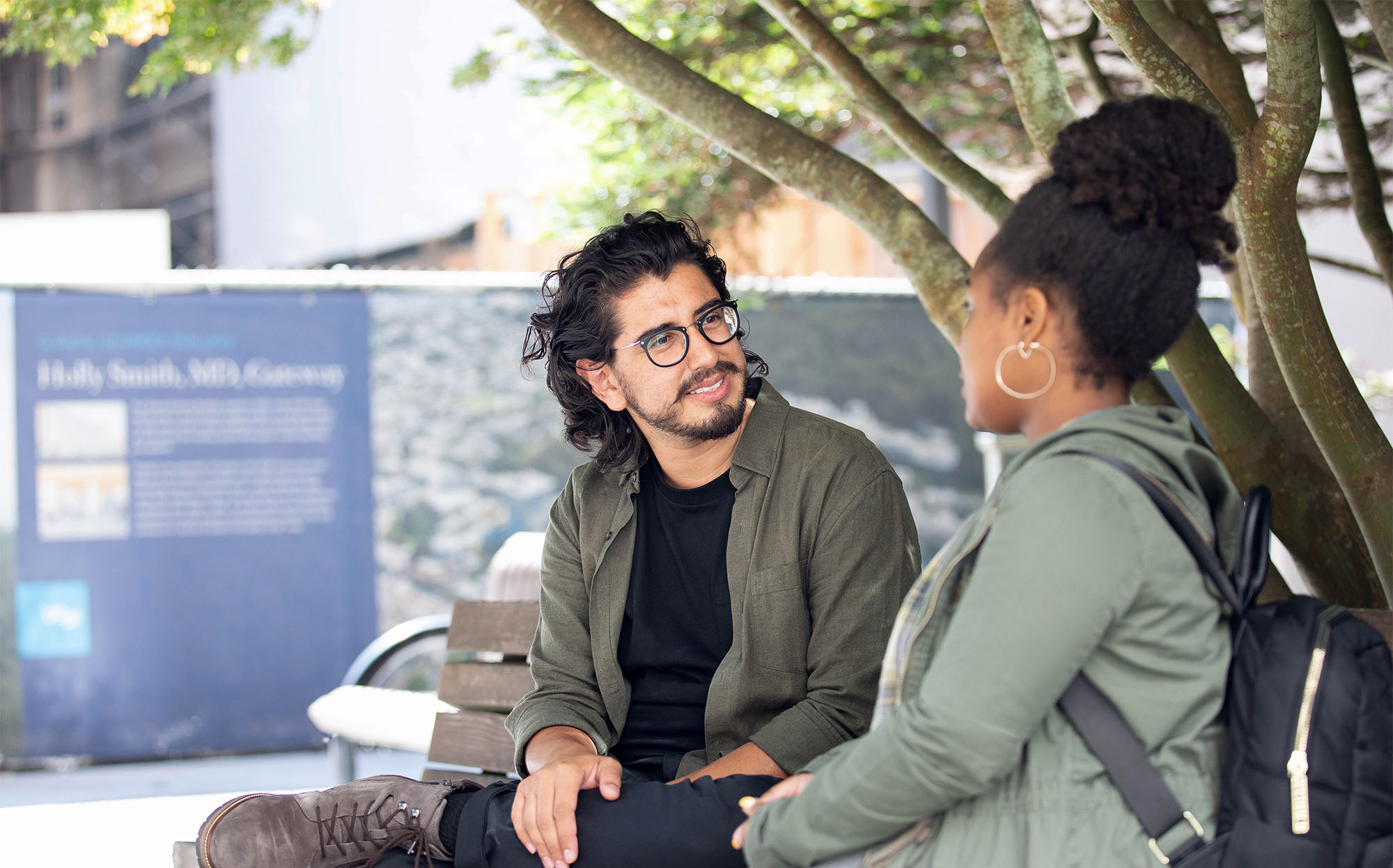 Photo of a hispanic man and black woman sitting and talking to each other